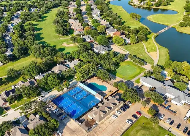 Aerial view of the Plantation Resort 1 amenity area — pool and courts surrounded by the golf course and a pond